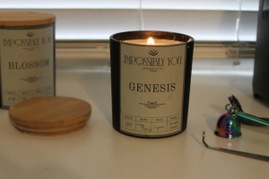 Large Impossibly You Scented Soy wax candles next to a lid and candle snuffer