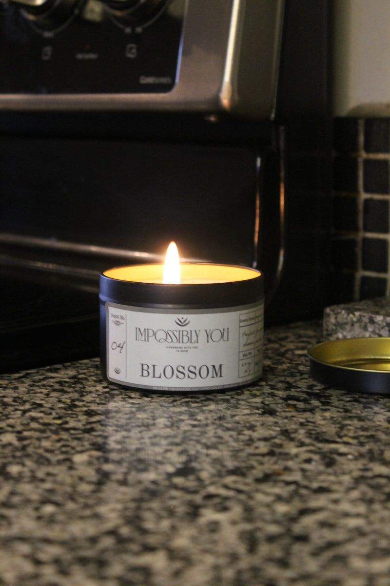 Blossom scented soy wax candle next to a stove in a kitchen.