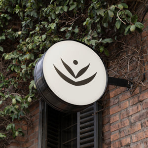 Impossibly You logo sign attached to a brick building.